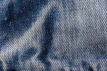 An image of close-up blue denim jeans fabric showing detailed texture with a dark blue color and a...