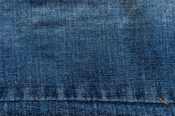 close-up blue denim jeans fabric showing detailed texture with a dark blue color and a stylish...