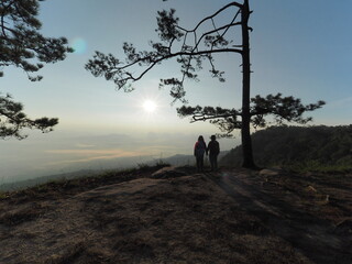 Loei Province, Thailand  27 June 2022, couple traveler watching sun rise at Nok Aen Cliff Phu...