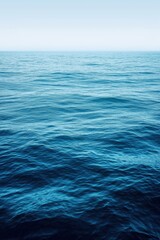 Fototapeta premium Deep blue ocean water surface merging with horizon on a misty day