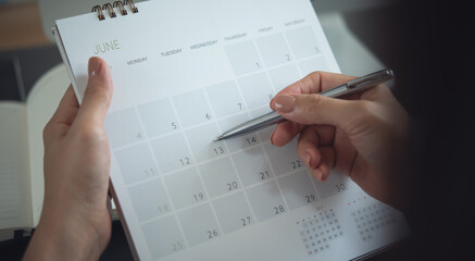 2025 Calendar event planning timetable agenda plan on organize schedule. Event planner agenda organizing by organizer schedule. Business woman hand writing on calendar planner on office table, closeup