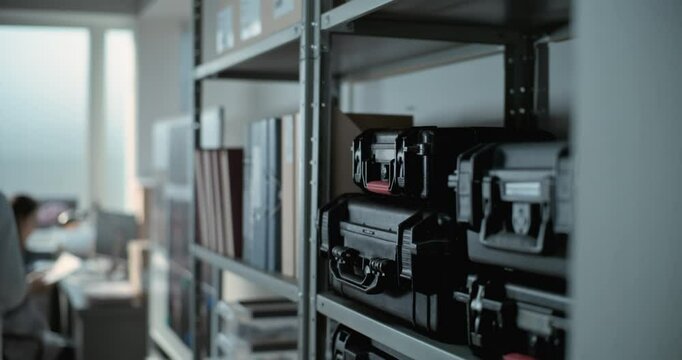 Modern and equipped archaeological scientific lab: Mature scientist or archaeologist in lab coat takes protective case with materials for fossil analysis from shelf with folders. Science concept.