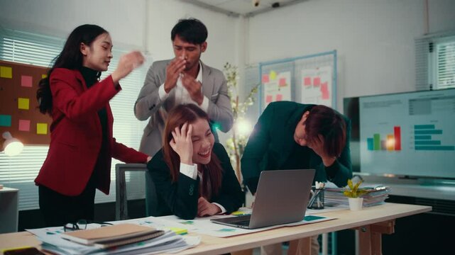 Business team is experiencing a stressful situation in the office. They are looking concerned at a laptop screen, suggesting bad news or a financial loss