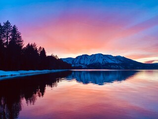 Bright pink sunset over mountains reflecting on lake tahoe