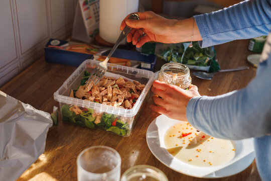Woman hands preparing tupper salad in rustic kitchen. Real people. Healthy food.