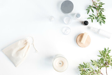 Flat lay composition with white blank cosmetic bottles, brown glass cosmetic dropper bottle for face serum or oil, pistachio branches on a white background. Skin care concept. 