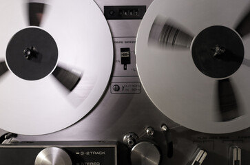 Vintage Music and sound - Closeup fragment retro spinning spool reel to reel tapes recorder