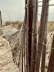 Weathered wooden fence on a sandy beach under an overcast sky at Tybee Island, Georgia