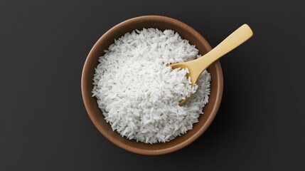 A bowl of steamed white rice served with a wooden spoon on a dark background, creating a minimalist and clean presentation.