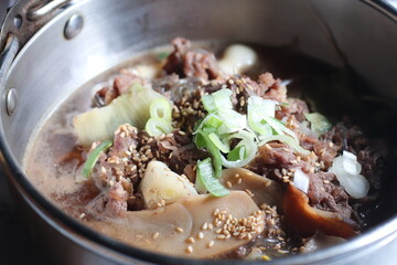 A close-up view of tender, marinated slices of beef bulgogi, glistening in a rich, savory sauce. The juicy beef is perfectly caramelized, capturing the essence of this classic Korean dish.