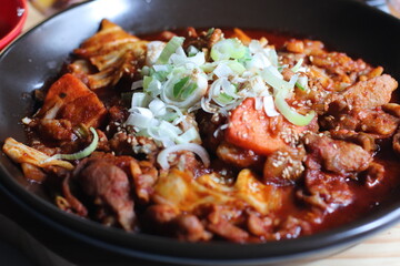 A flavorful dish of spicy stir-fried pork, coated in a rich, vibrant red sauce. The tender pork pieces are seasoned with garlic and chili paste, creating a bold and savory taste.

