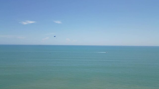 Open ocean view with a parasail in the distance and a speedboat