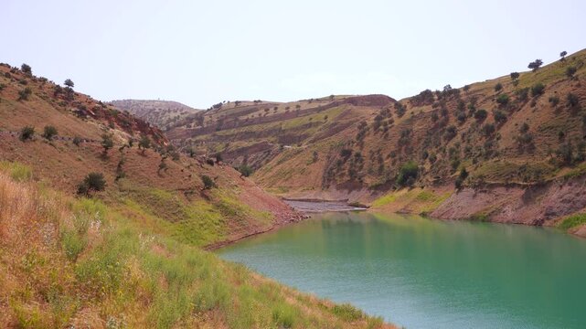 A river runs through a valley with a green color