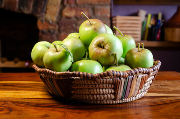 Close-up of green apples in a woven wicker basket