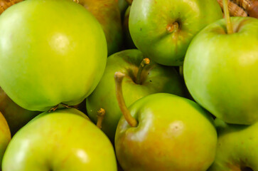 Close-up of green apples in a woven wicker basket