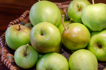 Close-up of green apples in a woven wicker basket