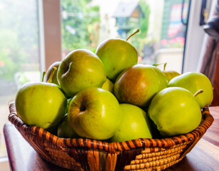 Close-up of green apples in a woven wicker basket