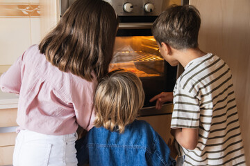 Kids In Kitchen And Waiting For Preparation Of Biscuits In Oven