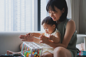 Obraz premium Asian woman playing with her child in the living room 