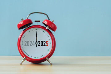 Happy new year 2025 concept.2024 change to 2025 on alarm clock on blue background. Copy space and...
