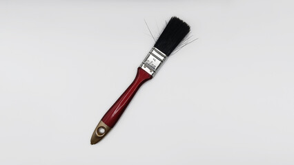 Red and Gold Paintbrush with Black Bristles on Isolated White Background.