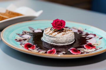 Gourmet Dessert Presentation with Elegant Rose-Petal Garnish on a Blue Ceramic Plate