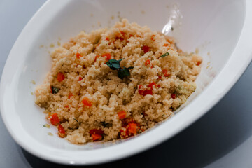 Gourmet Plated Couscous Salad with Fresh Vegetables and Herbs in Elegant Bowl
