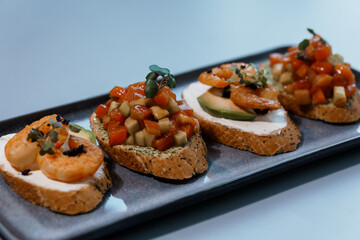 Gourmet Assorted Bruschetta with Fresh Vegetables, Shrimp, and Cream Cheese on Artisan Bread Platter