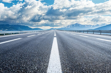 Fototapeta premium Empty highway leading to the mountains on a cloudy day