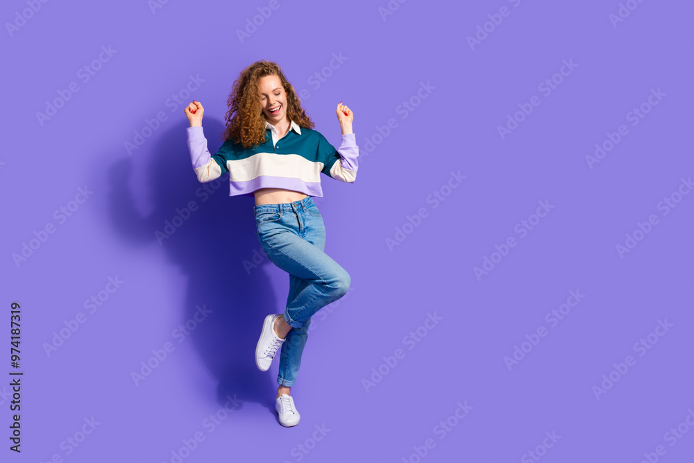 Wall mural Full size photo of nice young girl dance raise fists isolated on violet color background