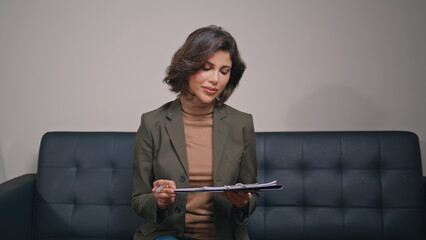 Business woman signing documents on clipboard in modern office closeup. 