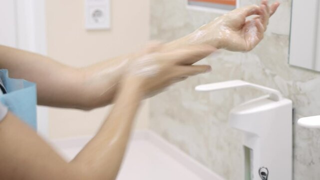 Close-up of a medical professional washing hands before surgery. Highlights crucial hygiene practices and meticulous preparation for maintaining a sterile environment.