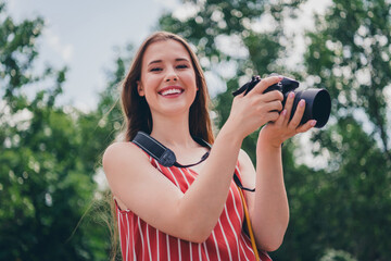 Photo of cheerful adorable girl wear trendy clothes walk city center take picture summer weather outdoors