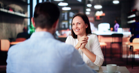 Laughing Male And Female Sitting In Cafe Drinking Coffee