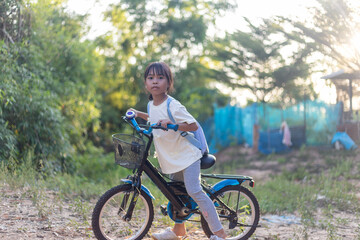 Fototapeta premium A young girl is riding a bicycle in a forest
