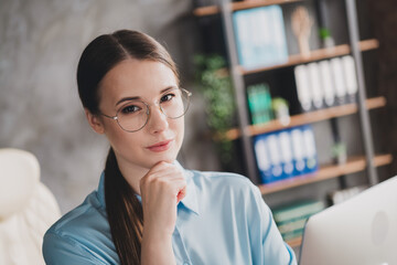 Fototapeta premium Photo of cheerful thoughtful lady recruiter dressed shirt eyewear arm chin indoors workplace workstation loft