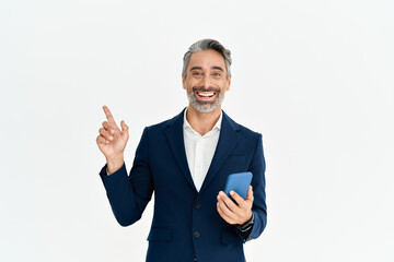 Happy business man of middle age holding phone pointing aside presenting ads. Smiling mature professional businessman in suit with smartphone using mobile banking app on cellphone isolated on white.