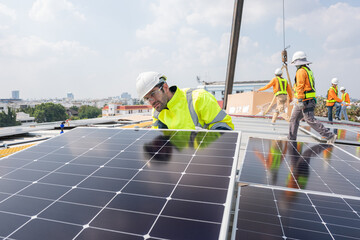 Men technicians carrying photovoltaic solar moduls on roof of factory on the morning. Installing a Solar Cell on a Roof. Solar panels on roof. Workers installing solar cell power plant eco technology.