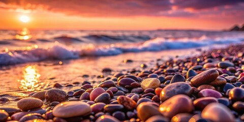 Obraz premium Wet pebbles on sea shore shining in pink sunset light