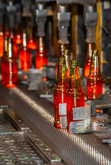 Glass factory, production of glass containers. Molten glass is blown into molds. Robotics in industry. Modern technologies, robotic machines produce products. Technological work at the plant.