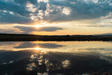 Calm water reflecting a dramatic sunset