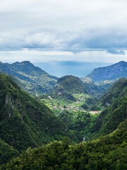 Hiking mountain trail among rocks and plants with a view of the clouds and gorge