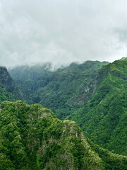 Fototapeta premium Hiking mountain trail among rocks and plants with a view of the clouds and gorge