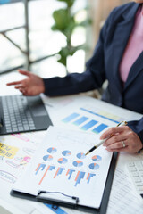 Accountants and marketers use calculators and laptop computers to calculate financial budgets, accounts, documents in files, graphs, charts, and office expenses. Business accounting concepts.