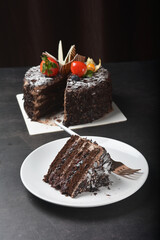 premium freshly baked dark cocoa chocolate brownie black forest blueberry jam round birthday cream cake with strawberry fruits on black table halal food sweet vegan dessert menu for pastry cafe shop