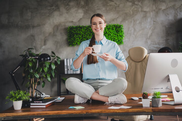 Photo of cheerful positive lady recruiter dressed shirt sitting table drinking coffee indoors...