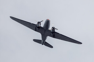 Old vintage and restored Dakota Douglas DC 3 passenger plane flying above the city of Haarlem,...