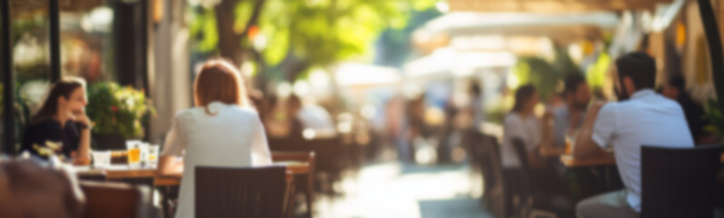Blurred background of People sitting at tables in outdoor cafe, on bustling street. Relaxed atmosphere, featuring individuals enjoying coffee and casual conversation in lively city environment.