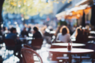 Fototapeta premium Blurred background of People sitting at tables in outdoor cafe, on bustling street. Relaxed atmosphere, featuring individuals enjoying coffee and casual conversation in lively city environment.