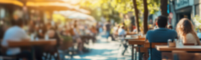 Obraz premium Blurred background of People sitting at tables in outdoor cafe, on bustling street. Relaxed atmosphere, featuring individuals enjoying coffee and casual conversation in lively city environment.